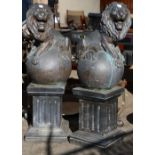 Pair of cast bronze lions statues, each lion seated on a globe and rising on a Doric columnar