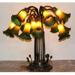 Tiffany style tulip table lamp, having 15 tulip form shades in orange to green, and rising on a