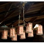 Hollywood Regency style light fixture, having eight cylindrical shades executed in red to cream,