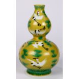 Chinese double gourd form porcelain vase, with sgraffito cranes amid green clouds on a yellow