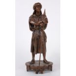 Patinated metal sculpture, modeled as a Moorish man standing astride, arms crossed, holding a