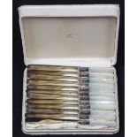 Cased Sheffield style mother of pearl handled dinner knives, each mounted with sterling ferrules,