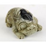 Chinese stone carving, of a mythical beast with a black patch on top of its head in contrast with