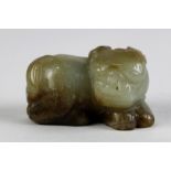 Chinese jade carving, of a recumbent mythical beast, executed from a russet and gray-white matrix,