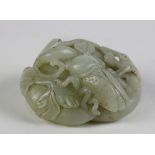 Chinese hardstone carving, featuring a fruiting vine with a cicada, executed from a celadon matrix