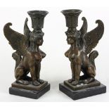 Pair of Egyptian Revival patinated bronze candlesticks, the palmette form bobeche above the sphinx