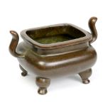 Chinese patinated bronze censer, of rectangular form flanked by shaped handles, and raised on