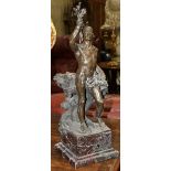 Patinated bronze figural sculpture, modeled as a nude male, depicted holding leaves in his right