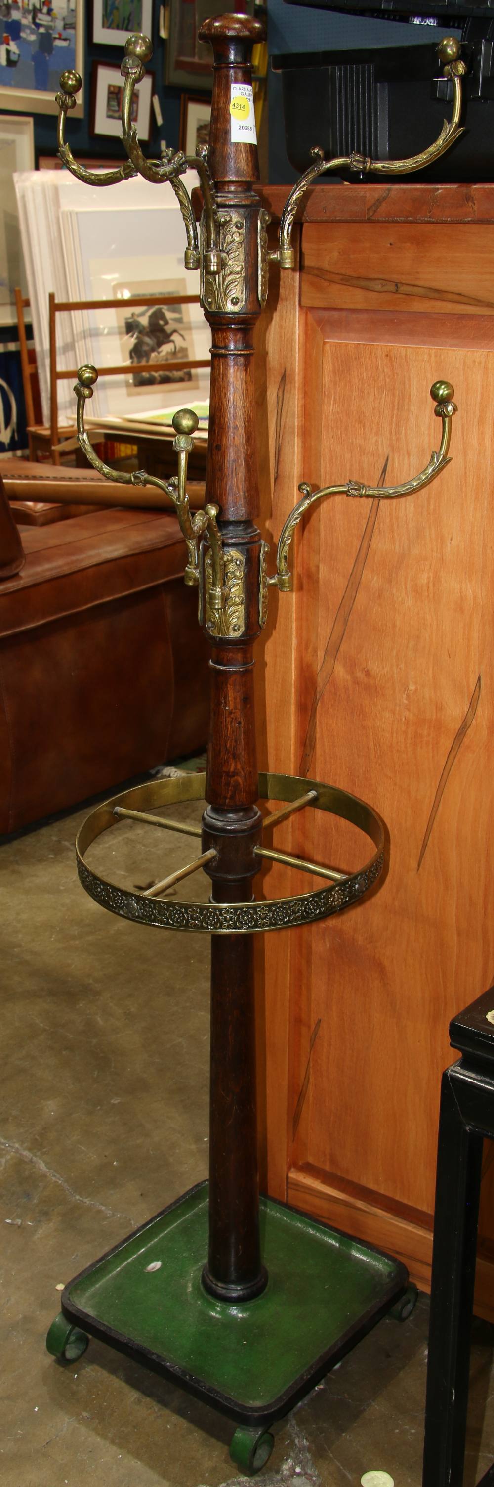 English coat rack, the turned wood standard with applied brass hooks, and rising on a cast iron