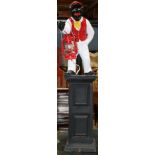 Outdoor garden lantern depicting a black Jockey carrying a red lantern, and rising on a plinth base,