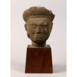 Khmer style stone head, the topknot fronted by a diadem, above the benevolent face, with stand,