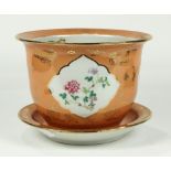 Chinese enameled porcelain planter and underdish, with floral reserves set agains a coral ground
