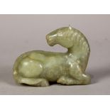 Chinese jade carving, of a recumbent horse, executed from a matrix of celadon hue, 4.5"w