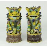 (lot of 2) Chinese famille jaune porcelain fu-lions, the yellow body accented by blue, green and