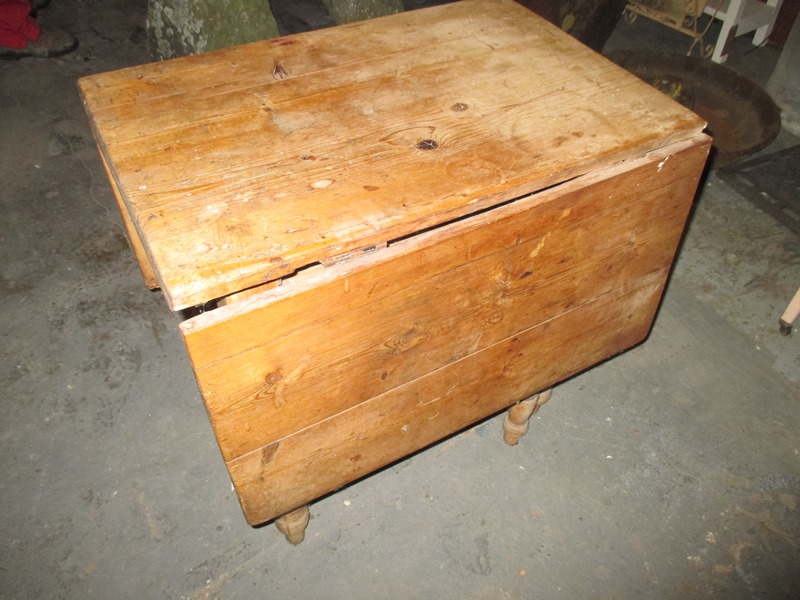 An antique pine drop leaf kitchen table