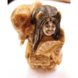 A 19th Century carved ivory Netsuke in the form of a figure with changeable face