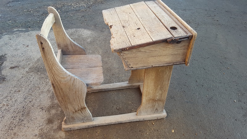 A vintage school desk and chair combination unit