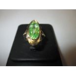 A gold ring marked 585 set with a large central peridot