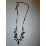 An Asian yellow metal necklace set with garnets