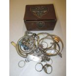 A quantity of silver and white metal jewellery items in a small copper box