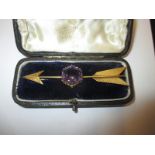 A 15ct gold arrow brooch set with large amethyst coloured stone