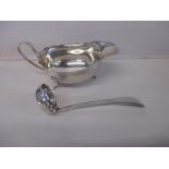 A sterling silver sauce boat and ladle