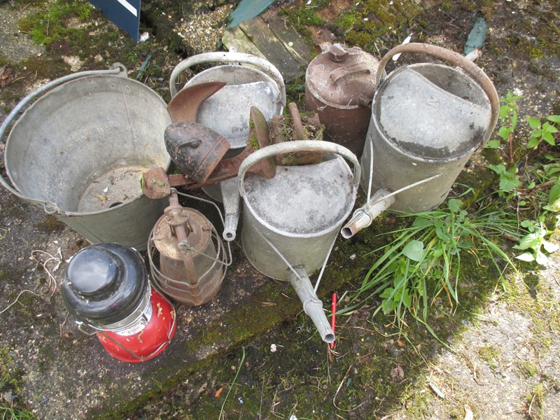 A quantity of vintage watering cans and other items