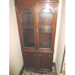 A small Edwardian glazed bookcase with cupboard base