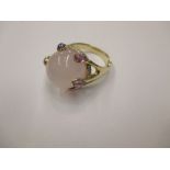 A 14ct gold ring set with a large central rose quartz stone surrounded by diamonds and amethyst