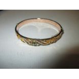 An Edwardian 9ct gold bangle set with seed pearls and Peridot