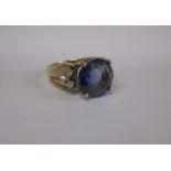 A 9ct gold and diamond ring set with a large central blue stone