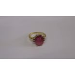 An 18ct gold ring set with a large central red stone