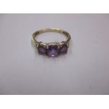 A 9ct gold ring set with purple sapphires and diamonds