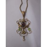 An early 20th century Art Nouveau necklace, the pendant set with a garnet and a seed pearl drop