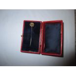 A 9ct gold stick pin set with a small ruby