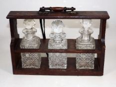 A Small Oak Tantalus With Three Cut Glass Bottles