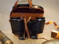 A Set Of Binoculars With Leather Case