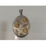A silver locket with engraved with foliates & appl