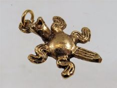 A yellow metal frog pendant