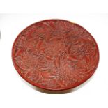 A Chinese red lacquer style dish with text to vers