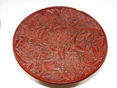 A Chinese red lacquer style dish with text to vers
