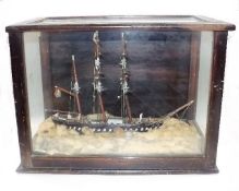A Model Of A Ship In Wood Framed Glass Cabinet