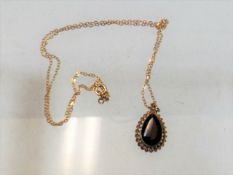 A small 9ct gold chain & pendant with garnet
