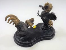 A bronze figurative sculpture of cocks fighting af