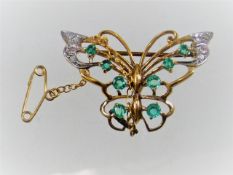 A gold butterfly brooch set with diamond & peridot