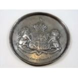 A pewter plaque with coat of arms inscribed James