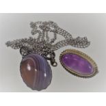 A silver mounted agate pendant twinned with amethy