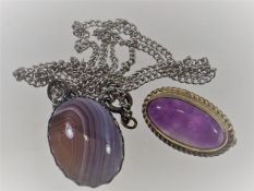 A silver mounted agate pendant twinned with amethy