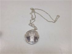 A silver medallion & white metal chain