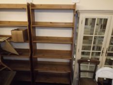 A tall set of open pine book shelves